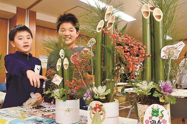 完成したミニ門松を披露する子どもたち＝浜田市黒川町、石見まちづくりセンター