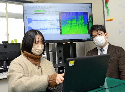 イノシシの鳴き声の波形を分析する西中涼乃さん(左)と、木下大助教=米子市彦名町、米子工業高等専門学校