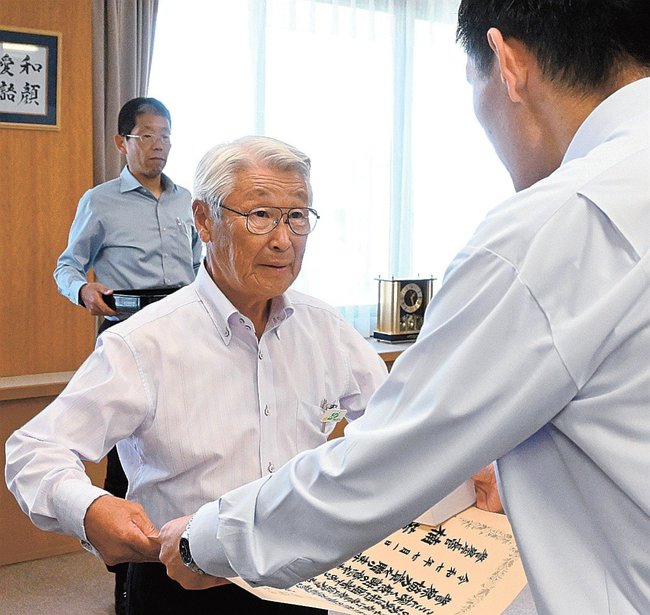 丸山直紀本部長（右）から表彰状を受け取る曽田耕市さん＝松江市殿町、島根県警