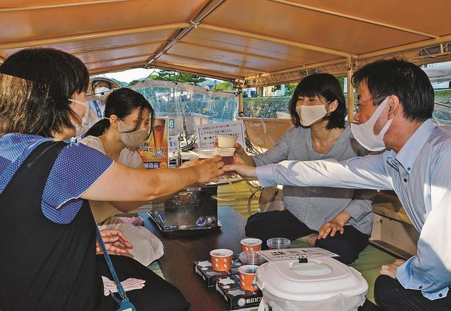 「０次会遊覧船」に乗って地ビールで乾杯する利用客＝松江市殿町、大手前広場乗船場