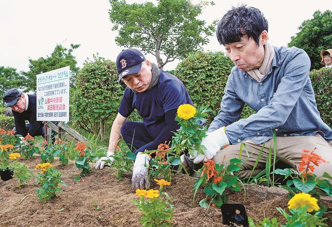 花壇に花の苗を植える会員たち＝浜田市笠柄町