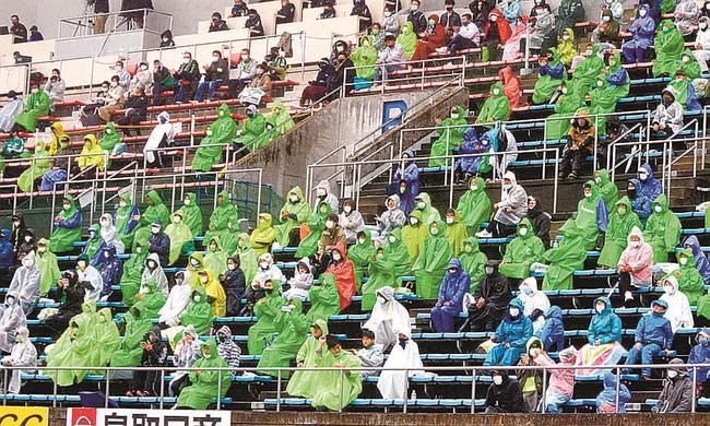 雨の中、試合の行方を見守るサポーター＝鳥取市蔵田、Ａｘｉｓバードスタジアム
