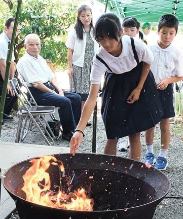 使い古した筆を炎にくべる参加者＝浜田市蛭子町、神並山天満宮
