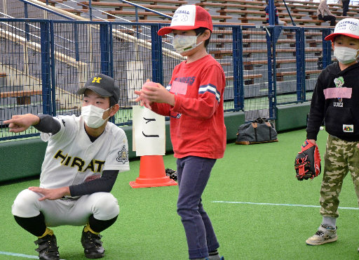 高校生にボールの投げ方を教わる子どもたち＝出雲市矢野町、出雲ドーム