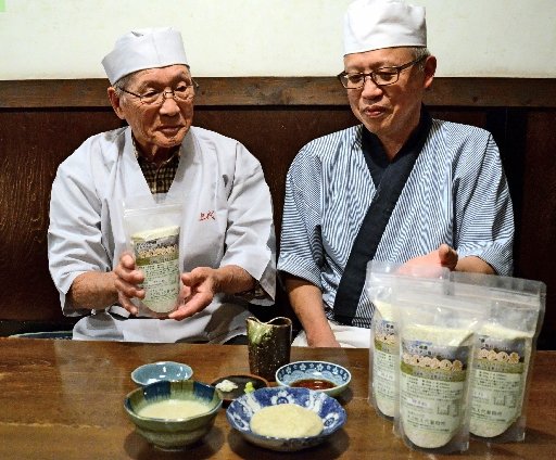 そばがゆの素を紹介する仲田春雄さん（左）＝米子市加茂町１丁目、そば処・上代