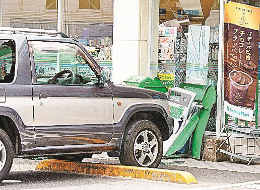 車止めを乗り越えコンビニエンスストアに突っ込んだ乗用車＝１１日午前１０時５１分、松江市学園南１丁目