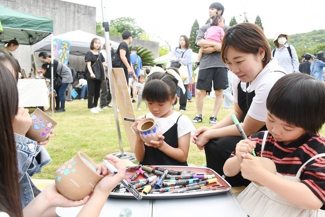 絵付けを楽しむ親子連れ＝松江市玉湯町玉造、玉造温泉ゆ～ゆ屋上広場