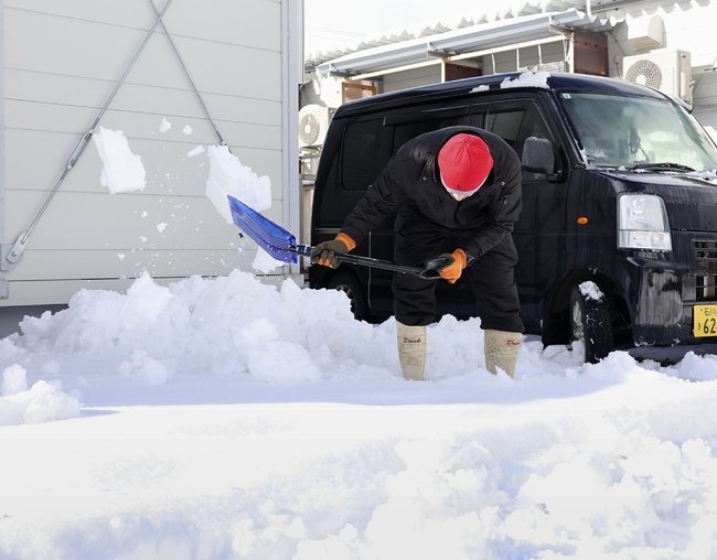 石川県輪島市の仮設住宅で、雪かきをする住民＝８日午後