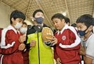  大谷翔平選手から贈られたグラブに触り、感触を確かめる吉田小の児童＝益田市中吉田町