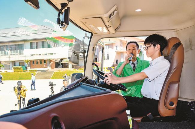 大型トラックの運転席に座り、視野を確認する生徒＝浜田市三隅町古市場、三隅中学校