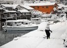 雪で岸壁と区別がつかなくなった町道の雪かきをする住民＝２８日午前７時１５分、島根県隠岐の島町港町