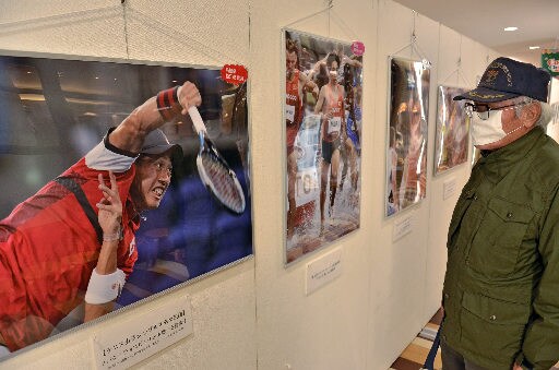 東京五輪・パラリンピックに出場した島根県ゆかりの選手の写真を見る来場者＝松江市東朝日町、イオン松江ショッピングセンター