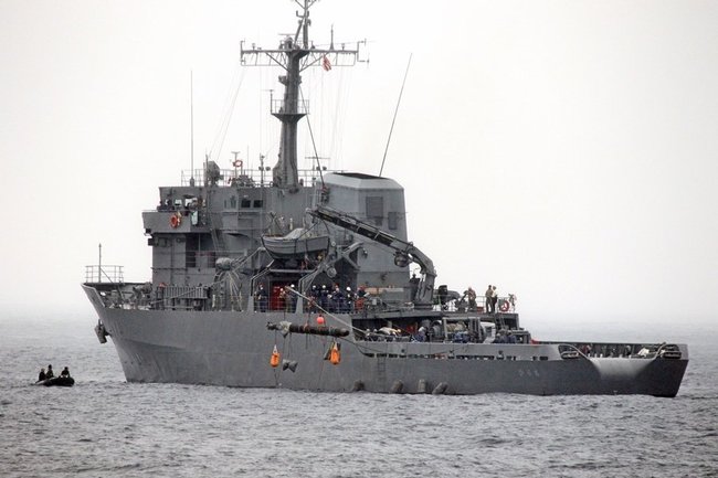 多用途支援艦「ひうち」のクレーンで回収される魚雷のような物体＝島根県隠岐の島町大久、大久漁港沖