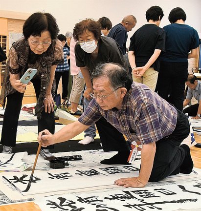講師（手前）の手本に見入る参加者＝出雲市平田町、平田行政センター
