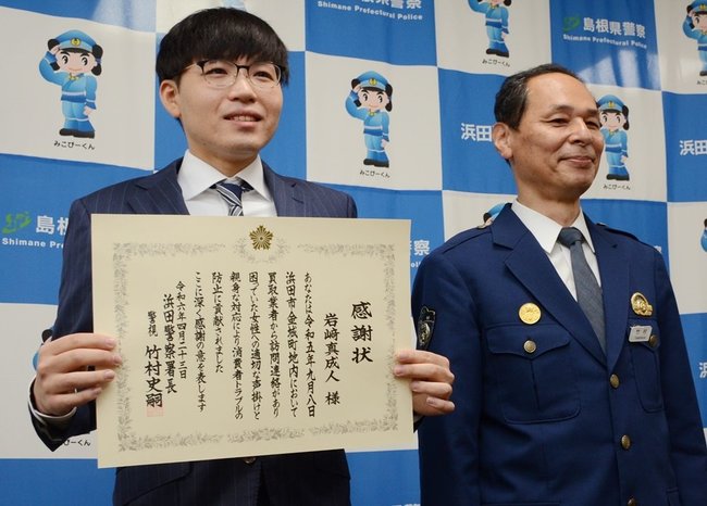 竹村史嗣署長（右）から感謝状を受け取った岩崎真成人さん＝浜田市黒川町、浜田署