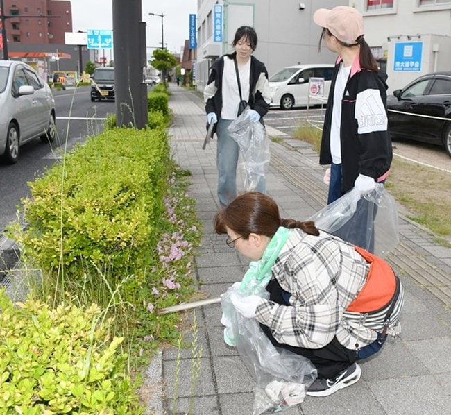 植え込みのごみを拾う参加者＝出雲市今市町