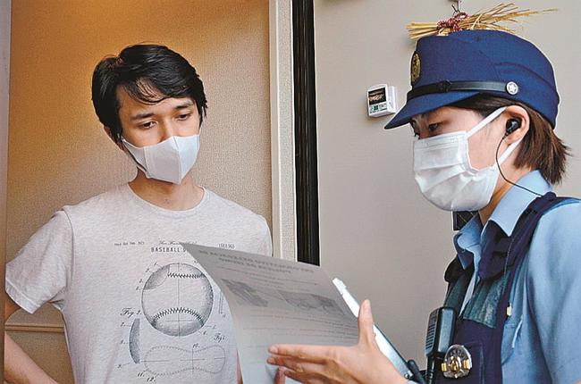 訪問先でポルトガル語を使って話しかける山尾波奈巡査長=出雲市天神町