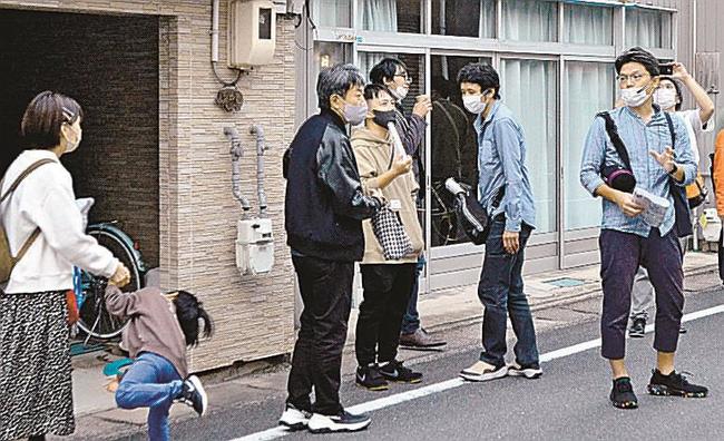 小笠原啓太さん（右）の案内でまち歩きする参加者＝松江市西茶町