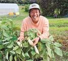 無農薬で育てた白ナスを手にほほ笑む吉岡大輔さん＝鳥取県大山町長野