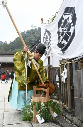 御饌井からくみ上げた若水をおけに移す神職＝出雲市大社町杵築東、出雲大社