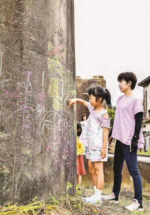 旧ＪＲ三江線の橋脚にチョーク絵を描く来場者＝江津市江津町