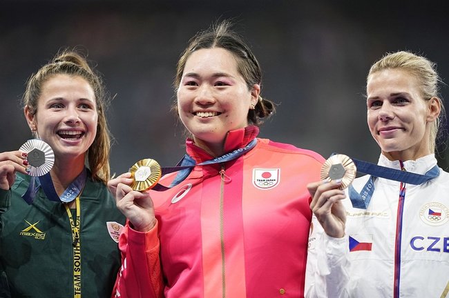 パリ五輪の陸上女子やり投げで優勝し、表彰式で笑顔を見せる北口榛花選手（中央）。日本選手は海外の五輪で最多の２０個の金メダルを獲得した＝８月１０日、パリ郊外（共同）