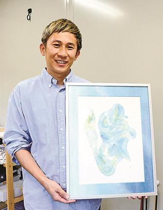 水を使って書いた「夢」を手に持つこーたさん＝松江市西生馬町