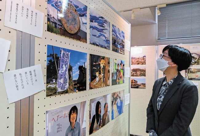 東日本大震災の被災地の写真を見る職員＝松江市西川津町、島根大学付属図書館