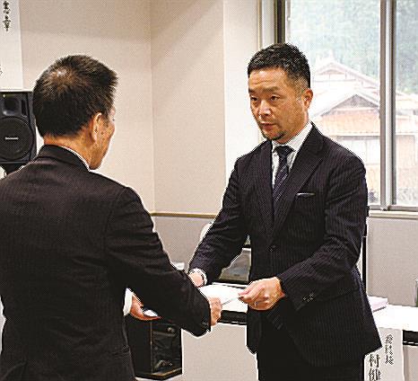 石橋良治町長（左）に報告書を手渡す中村健太委員長＝島根県邑南町矢上、町役場