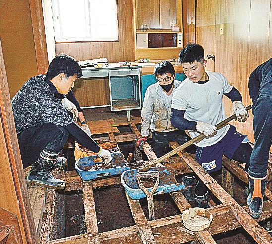 床下に堆積した土砂をかき出すボランティア＝出雲市口宇賀町