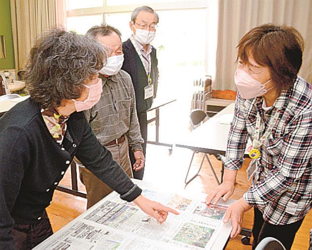 27日付の山陰中央新報を囲み談笑する参加者=浜田市金城町小国、小国まちづくりセンター