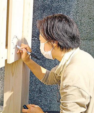 すずさんの家（こうの史代さんの祖父母の家跡）でイノシシよけの落書きをするこうのさん＝広島県内