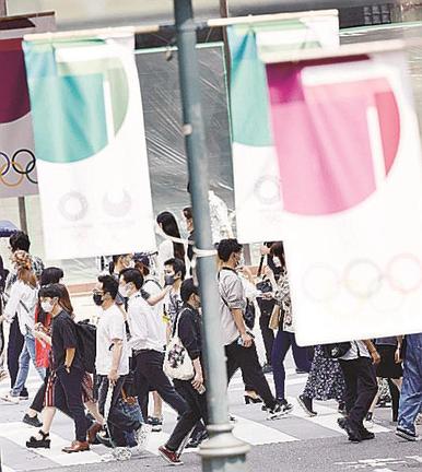 東京五輪・パラリンピックのバナーが掲げられた東京・渋谷の街を行き交うマスク姿の人たち＝７日午後