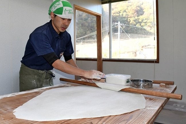 真剣な表情でそばを打つ田尾海星店長＝島根県奥出雲町八川、高原そば壱心