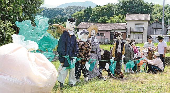 大きなカブを引っ張る様子を表現したかかし＝大田市三瓶町