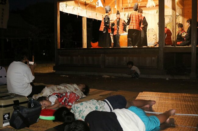 勇壮な剣舞が舞われる中、寝入る子どもたち＝１７日午前４時１５分、島根県隠岐の島町久見、伊勢命神社