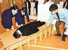 段ボールベッドの寝心地を確かめる生徒〓（?）江津市桜江町川戸、桜江中学校
