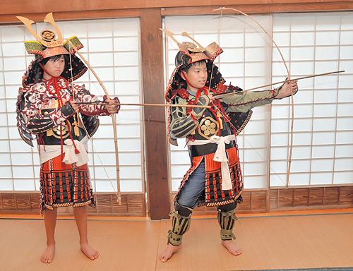 自分たちで作った弓矢を構える渡部ありささん（左）と森脇遼也君＝島根県奥出雲町小馬木、安養寺