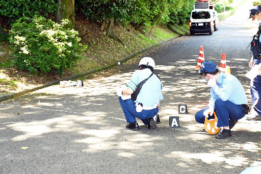 自転車同士が衝突した事故現場を調べる捜査員=鳥取市湖山町南4丁目、鳥取大学