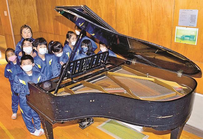 大火を逃れたピアノに触れる児童＝島根県奥出雲町三成、三成小学校