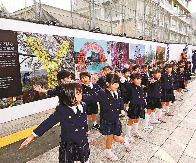 手形アートを前に踊りを披露する幼稚園児＝米子市弥生町、ＪＲ米子駅