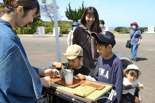 出店でお茶を買い求める来場者＝浜田市国分町、石見海浜公園