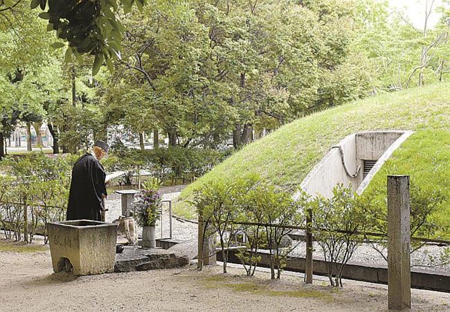 原爆供養塔前に置かれている献花用の石製の鉢（左下）。撮影した７月６日時点では異常はなかった