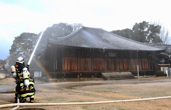 万福寺の本堂に放水する署員＝益田市東町