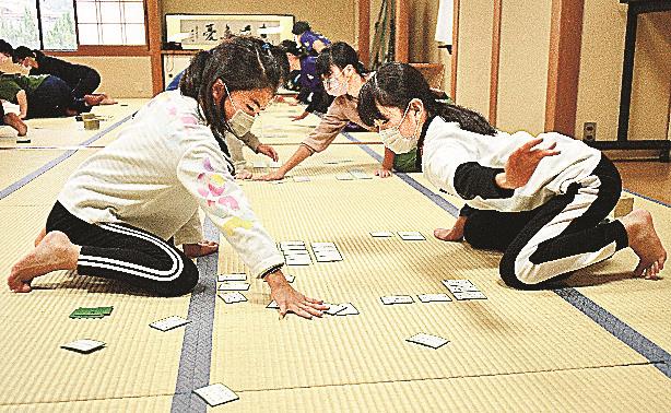 素早く手を伸ばし、札を払う参加者＝益田市元町、市民学習センター