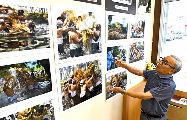 雨乞い神事の様子を活写した写真を紹介する吉崎佳慶さん＝益田市中吉田町、キヌヤ中吉田店