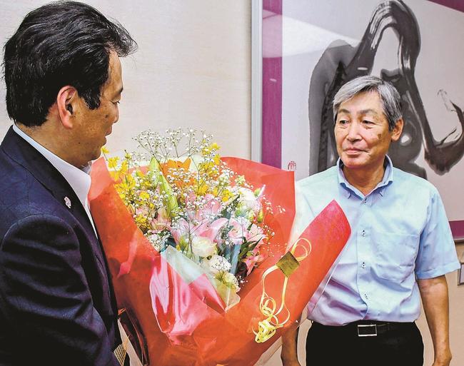 飯塚俊之市長（左）に花束を贈る生産者＝出雲市今市町、市役所