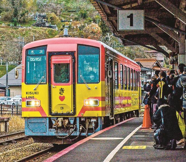 ラッピング列車を出迎える関係者ら＝雲南市木次町里方、ＪＲ木次駅