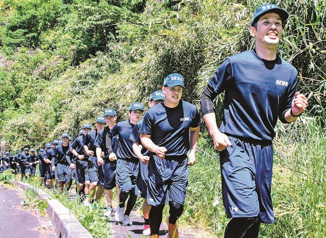 上り坂を懸命に走る消防学校生＝松江市宍道町佐々布