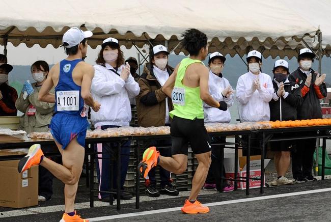 国宝松江城マラソンで、手を叩いてランナーを応援するボランティアスタッフ＝２０２２年１２月４日、松江市美保関町下宇部尾